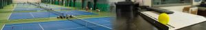 Indoor tennis facility with multiple blue courts and players practicing, netting and green walls across the scene; on the right, a yellow tennis ball rests on a desk with a calculator and papers nearby.